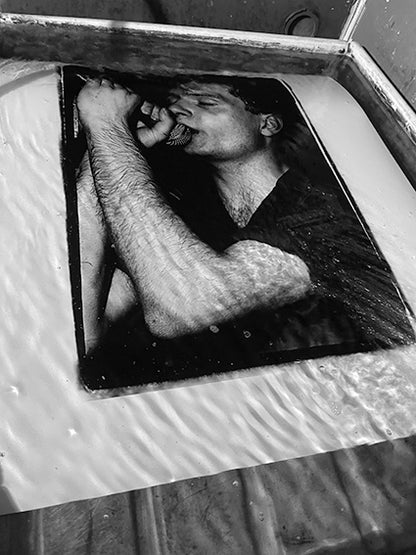Ian Curtis - Joy Division | Moonlight Club, 1980. Silver gelatin print by Peter Anderson being hand-developed in a darkroom tray.
